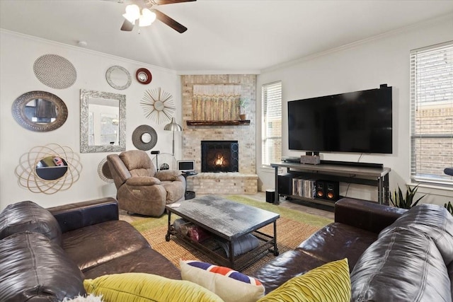 living room with ornamental molding, a healthy amount of sunlight, ceiling fan, and a fireplace