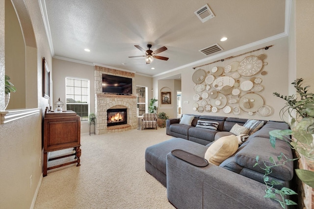 living room with a stone fireplace, a textured ceiling, ornamental molding, carpet flooring, and ceiling fan