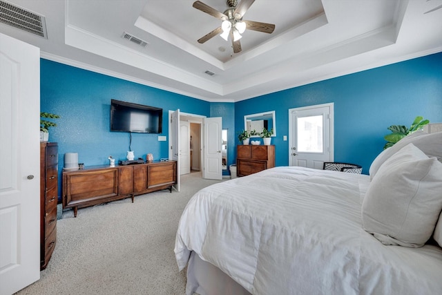 carpeted bedroom with crown molding, ceiling fan, and a tray ceiling