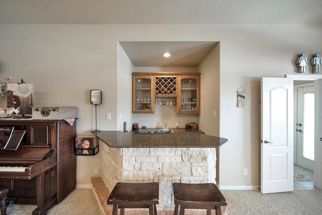 bar with light colored carpet and dark stone counters