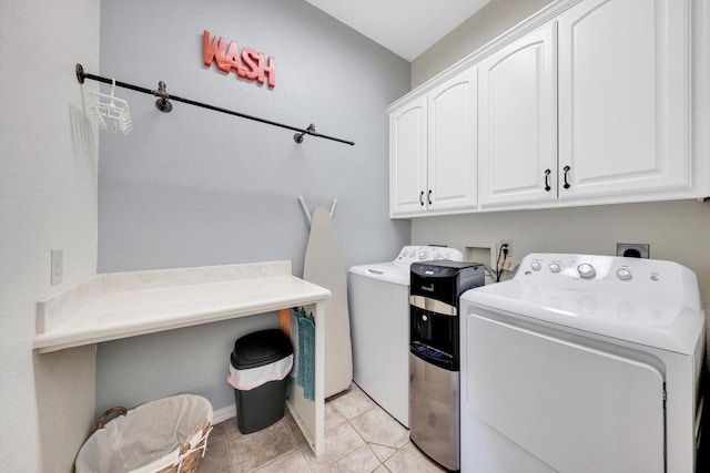 laundry area featuring cabinets, light tile patterned flooring, and independent washer and dryer