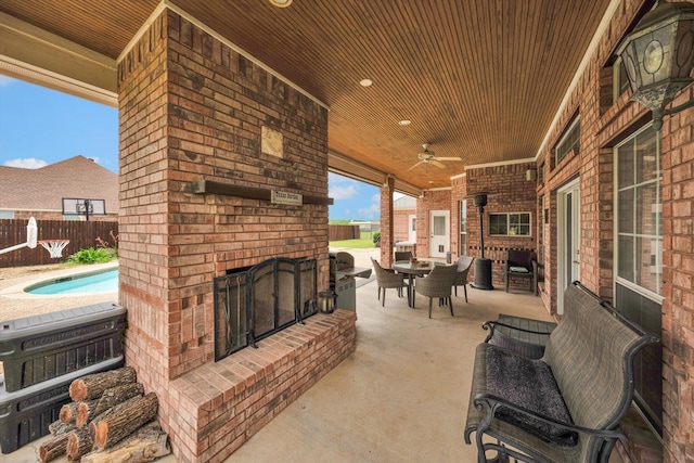 view of patio with an outdoor brick fireplace, a fenced in pool, and ceiling fan