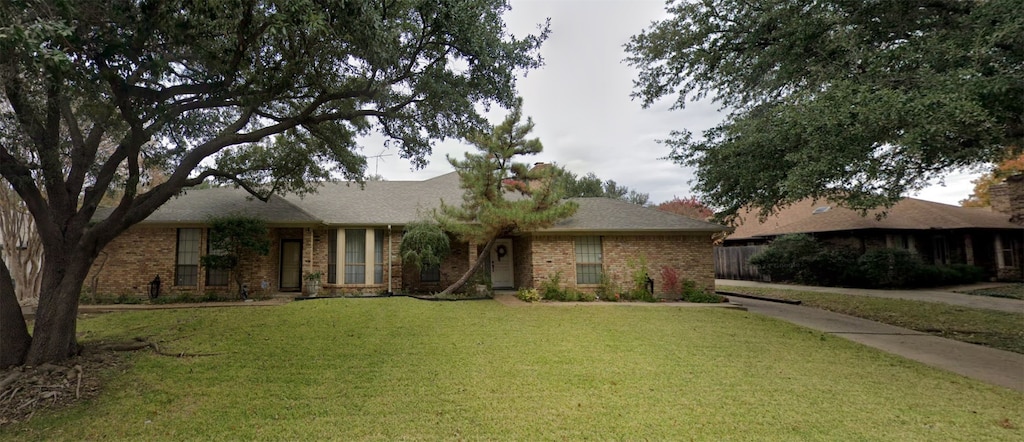 single story home featuring a front lawn