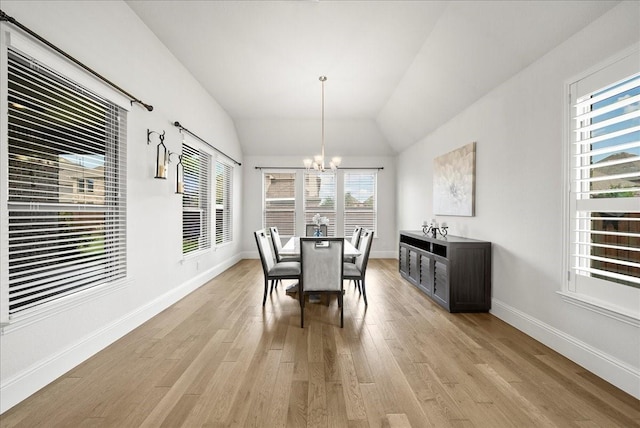 dining area featuring lofted ceiling, light hardwood / wood-style flooring, and a chandelier