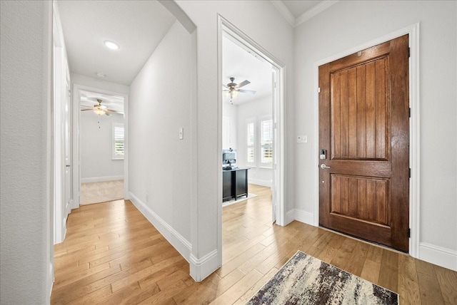 entrance foyer featuring crown molding, plenty of natural light, ceiling fan, and light hardwood / wood-style floors