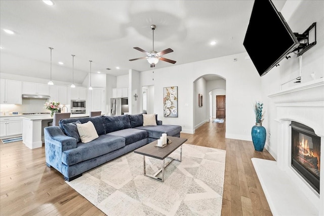 living room with ceiling fan and light wood-type flooring