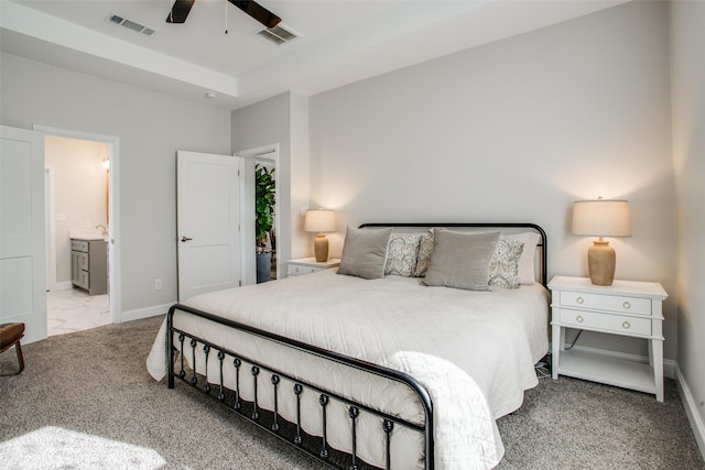 bedroom with light carpet, ensuite bath, and ceiling fan