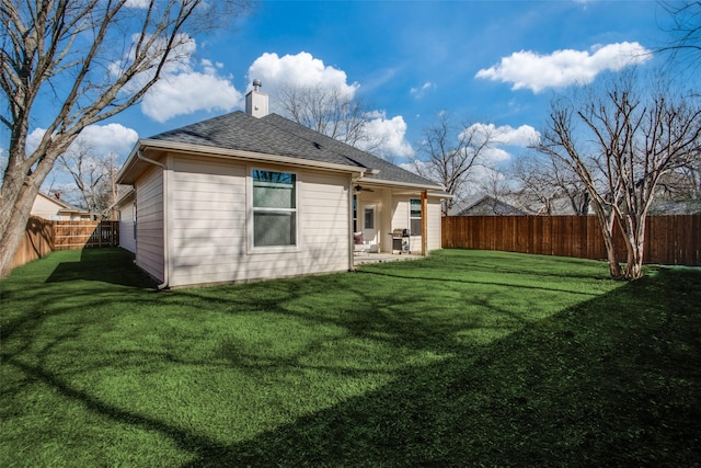 back of property with a yard and a patio area