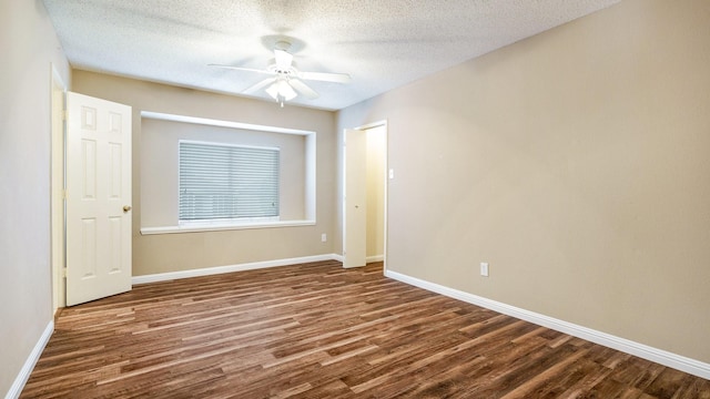 spare room with a ceiling fan, baseboards, a textured ceiling, and wood finished floors