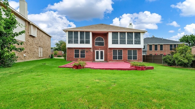 back of house with fence, a sunroom, a yard, and brick siding