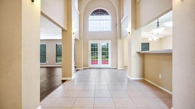 tiled foyer entrance with a towering ceiling and ceiling fan