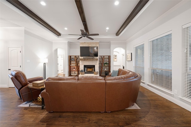 living room with a fireplace, beam ceiling, dark hardwood / wood-style flooring, and ornamental molding