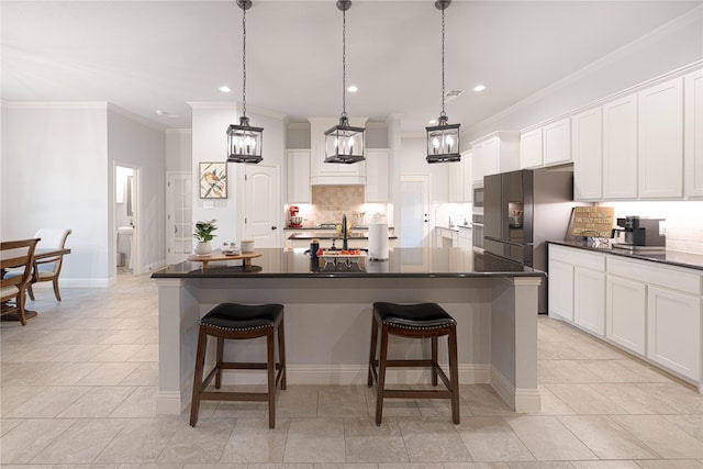 kitchen featuring an island with sink and white cabinets