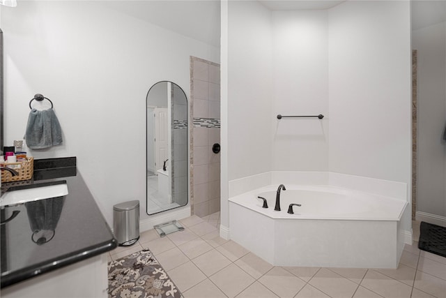 bathroom featuring plus walk in shower, sink, and tile patterned flooring