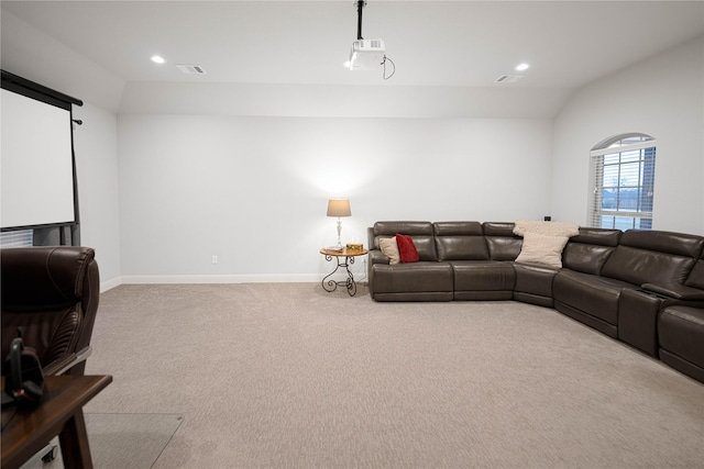 home theater featuring light carpet and vaulted ceiling