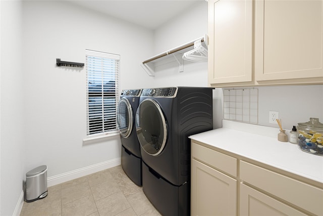 clothes washing area featuring light tile patterned flooring, independent washer and dryer, and cabinets