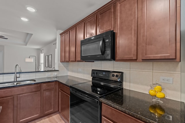 kitchen with tasteful backsplash, dark stone countertops, sink, and black appliances