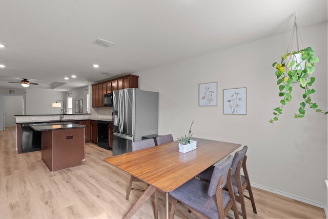 dining area featuring sink, ceiling fan, and light hardwood / wood-style flooring