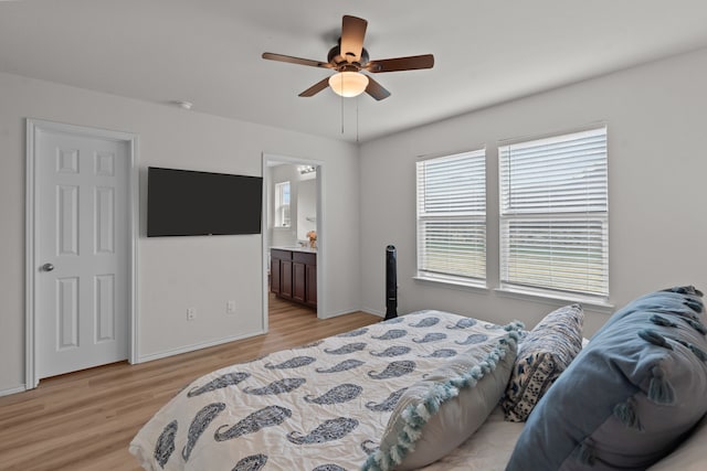 bedroom featuring ceiling fan, ensuite bathroom, and light wood-type flooring