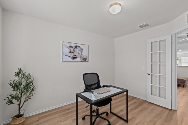 bedroom with a nursery area, ceiling fan, and light hardwood / wood-style flooring