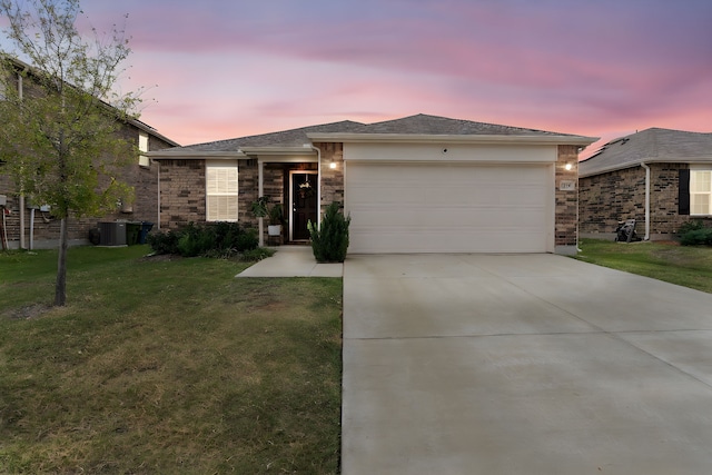 view of front facade featuring central AC, a yard, and a garage