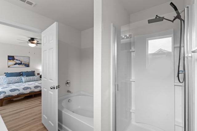 bathroom featuring ceiling fan, wood-type flooring, and separate shower and tub