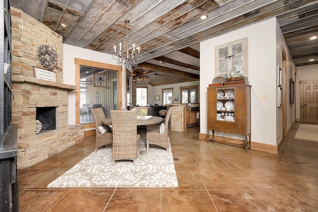 dining room featuring a stone fireplace, beamed ceiling, and a chandelier