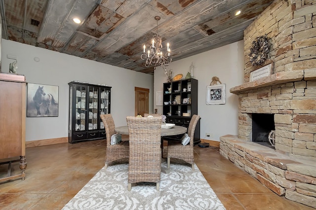 dining area with a stone fireplace and a notable chandelier