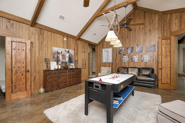 playroom with ceiling fan, tile patterned floors, wooden walls, and vaulted ceiling with beams