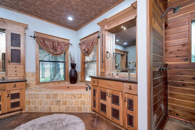 bathroom featuring vanity, ornamental molding, and tiled bath