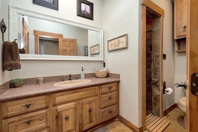 bathroom with vanity, toilet, tile patterned flooring, and a shower