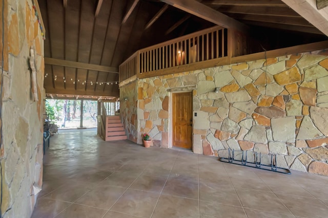 interior space featuring tile patterned flooring and high vaulted ceiling