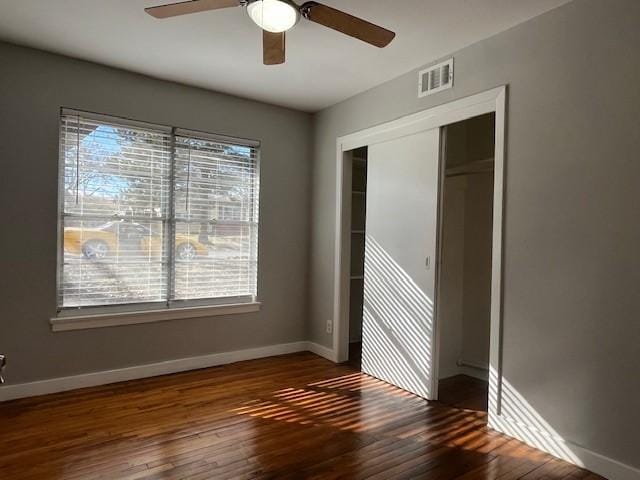 unfurnished bedroom featuring dark hardwood / wood-style flooring, a closet, and ceiling fan