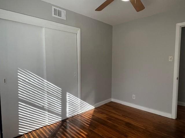 empty room with dark hardwood / wood-style flooring and ceiling fan