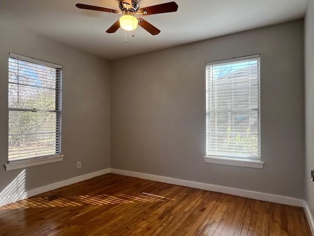 spare room featuring dark wood-type flooring and ceiling fan