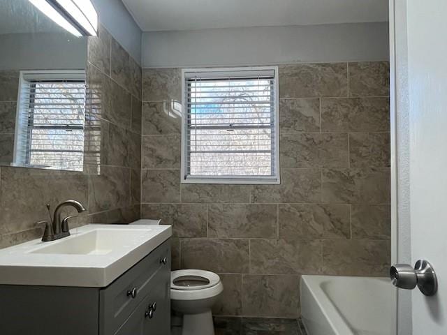 bathroom featuring tasteful backsplash, vanity, toilet, and tile walls