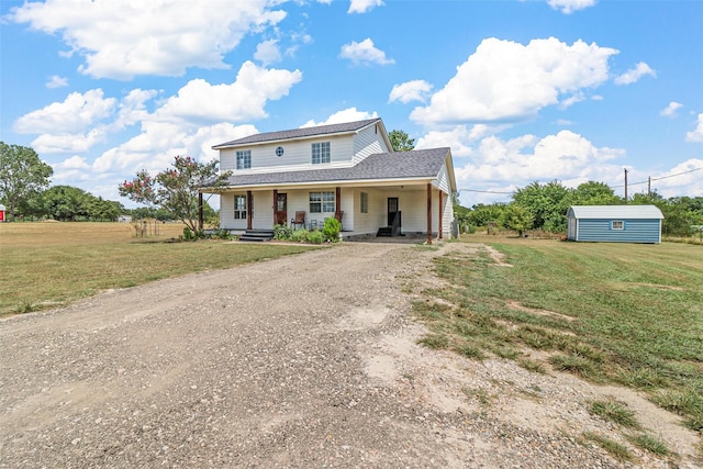 view of property with a storage shed, covered porch, and a front lawn