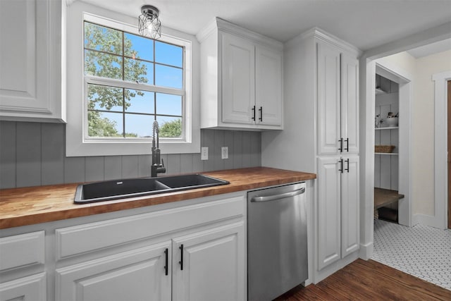 kitchen with white cabinetry, wooden counters, dishwasher, and sink