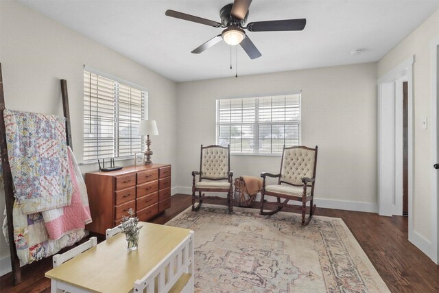 living area featuring dark hardwood / wood-style flooring, plenty of natural light, ceiling fan, and baseboard heating