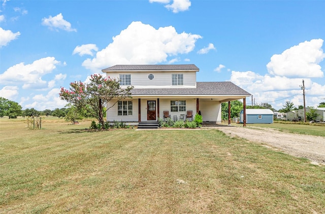 view of front of house with a front yard, a carport, and covered porch