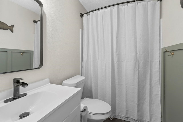 bathroom featuring vanity, toilet, a shower with shower curtain, and a textured ceiling