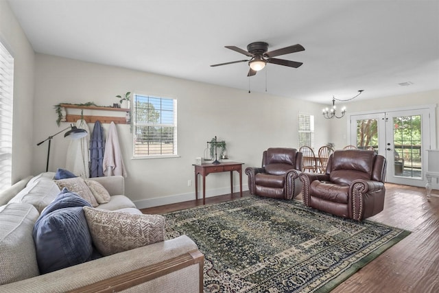 living room with wood-type flooring and ceiling fan with notable chandelier