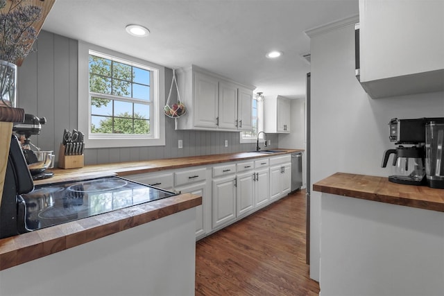 kitchen featuring sink, dark hardwood / wood-style flooring, white cabinets, wood counters, and stainless steel dishwasher