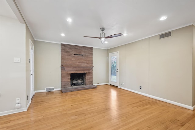 unfurnished living room featuring a fireplace, crown molding, light hardwood / wood-style flooring, and ceiling fan