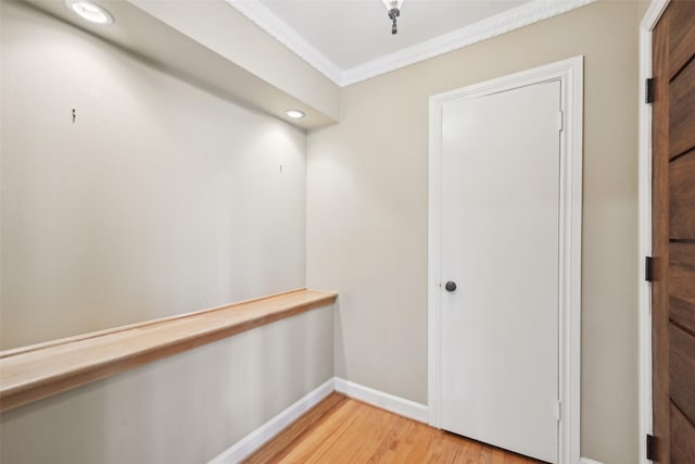 hall featuring ornamental molding and light hardwood / wood-style floors