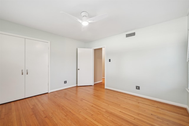 unfurnished bedroom with light hardwood / wood-style flooring, ceiling fan, and a closet