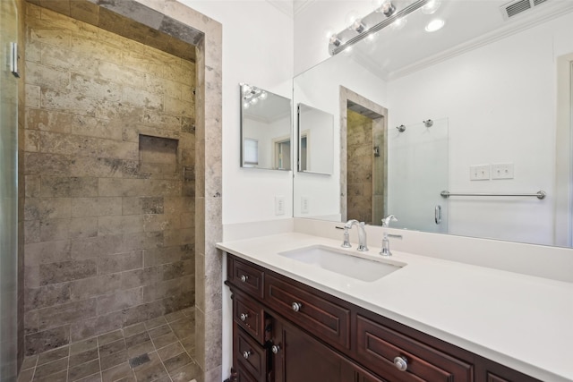 bathroom featuring vanity, crown molding, and tiled shower