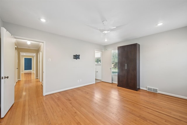 empty room with ceiling fan and light hardwood / wood-style floors