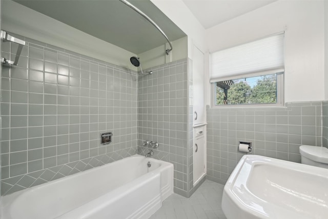 bathroom featuring tile walls, tile patterned flooring, toilet, and tiled shower / bath