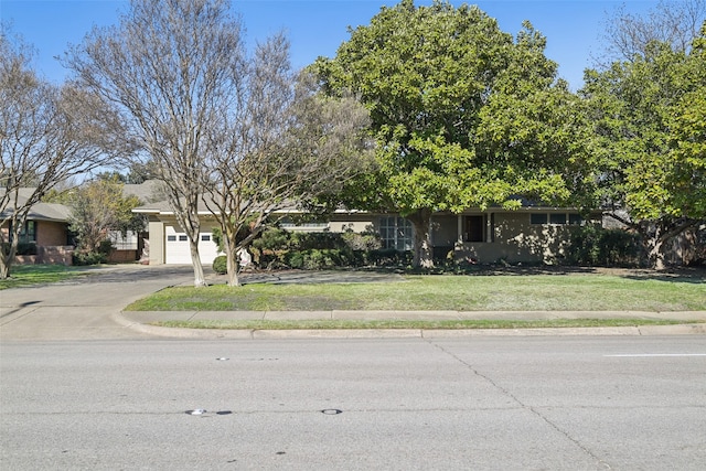 obstructed view of property featuring a garage and a front lawn